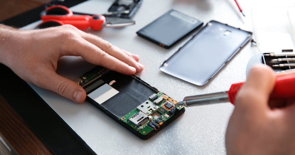 a person repairing a phone with a soldering iron