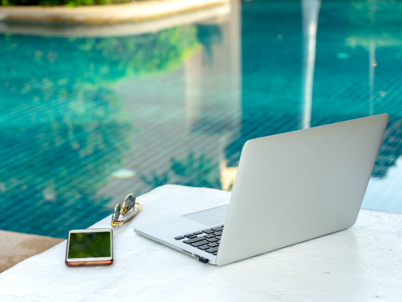 A phone and laptop near a pool